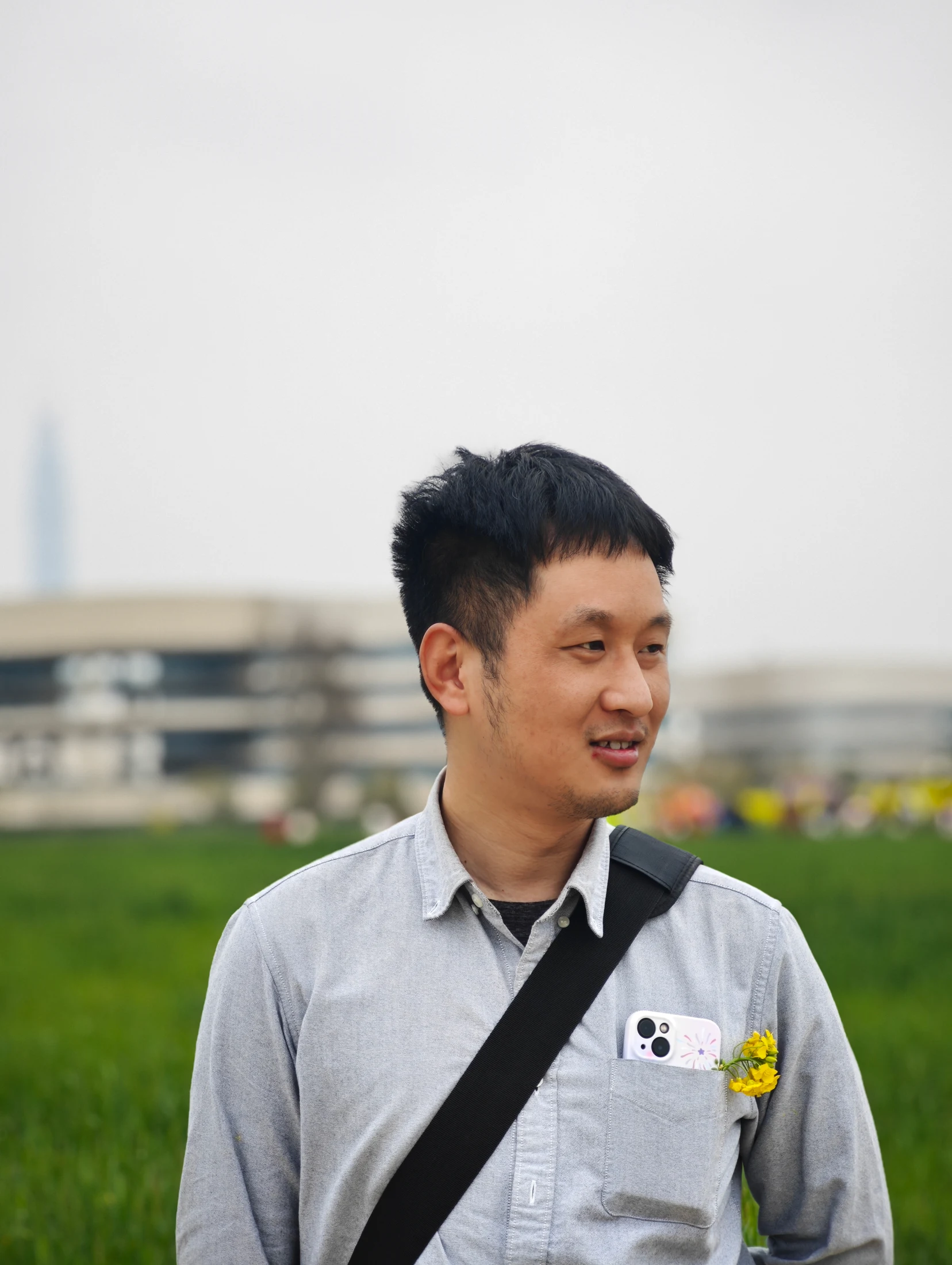 许旭祥穿着灰色衬衣走在城市里